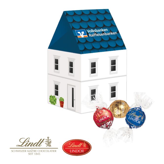 Firmengeschenk Lindt Lindor 3D Präsent Haus – bunt – mit bedrucktem Etikett 100 g als Weihnachtsgeschenk für Kunden und Partner